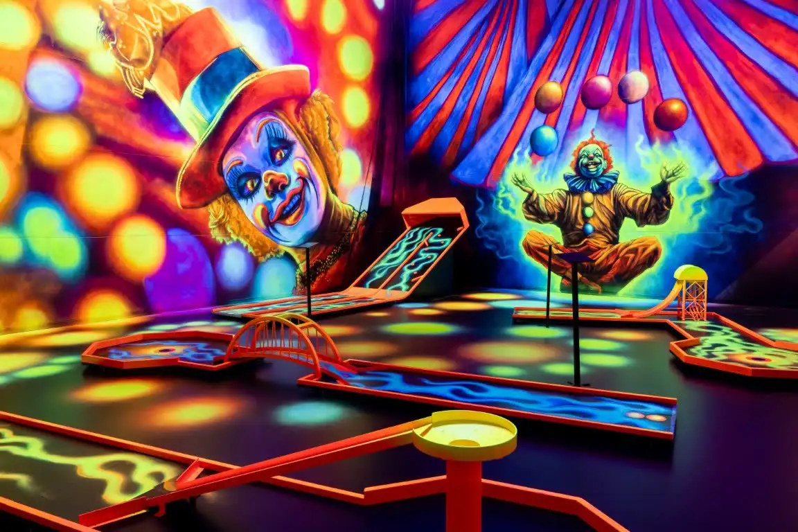 Manege mit Clown und bunten Bällen über den Bahnen.