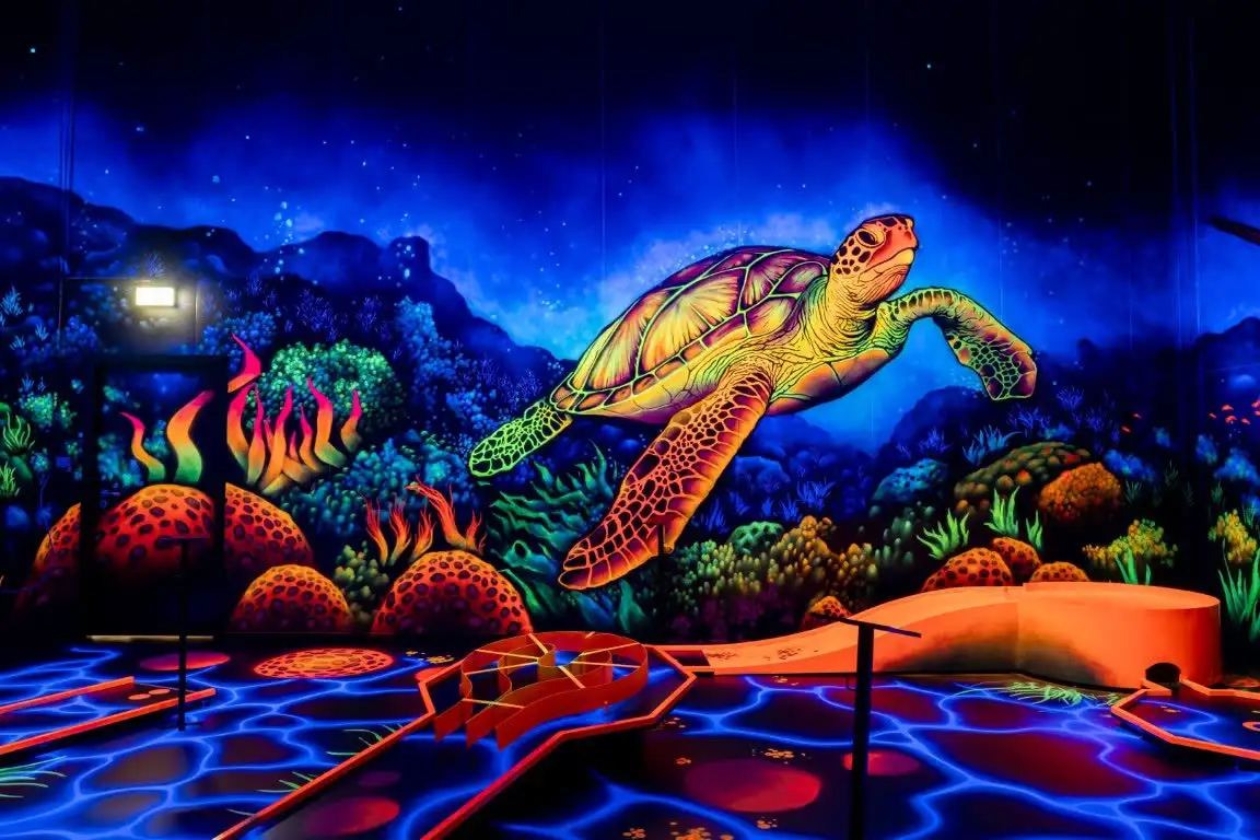 Große leuchtende Schildkröte an der Wand der Unterwasserwelt.
